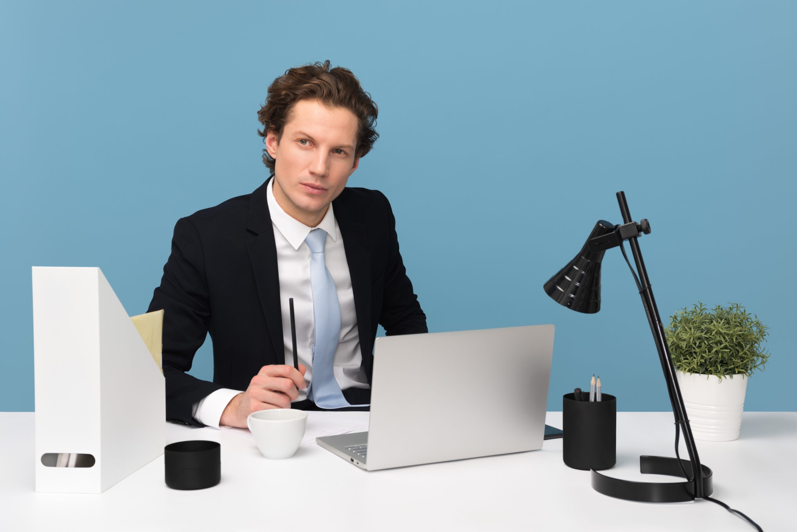 man-sitting-with-laptop-computer-on-desk-and-lamp-1586996 Hombre pensando y enfocado en los resultados de sus negocios